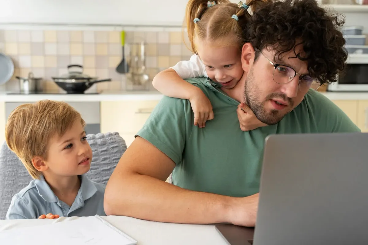 Ein Elternteil arbeitet von zu Hause und kümmert sich um zwei kleine Kinder